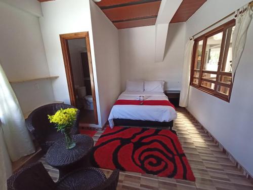 a small room with a bed and two chairs at Hotel Malaki in San Agustín