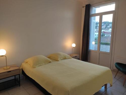 une chambre avec un grand lit et une fenêtre dans l'établissement F3 moderne proche marché et mer, à Saint-Raphaël