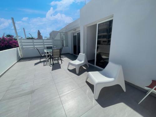 Un balcón con una mesa y sillas en un tejado. en Christina Apartment, en Protaras