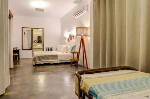 a hotel room with two beds and a mirror at A Casa de Gabriella in Itacaré