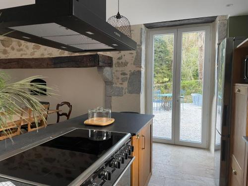 uma cozinha com fogão forno superior ao lado de uma janela em Le Val Éveillé 4 étoiles - maison de maître de 1773 em Arudy