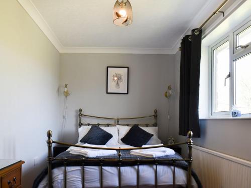 a bedroom with a bed and a window at Mill Lea Cottage in Onecote