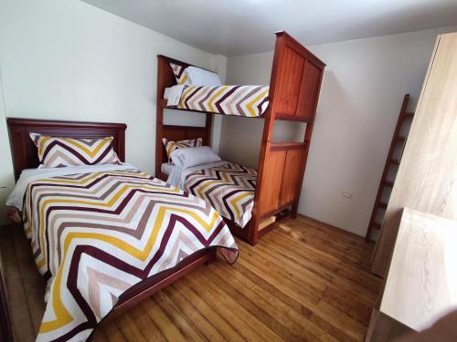 1 dormitorio con 2 literas y suelo de madera en Dulce Hogar 02 en Loja
