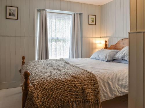 a bedroom with a bed and a window at Zion Cottage in Gorran Haven