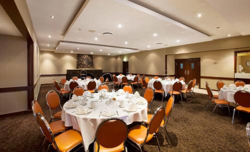a conference room with tables and chairs with white tablecloths at Nightelier Mermaid Waters in Gold Coast