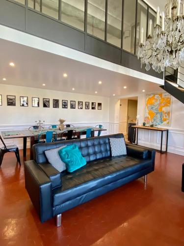 a black leather couch in a living room with a table at Les Suites du Cours & Spa in Aix-en-Provence