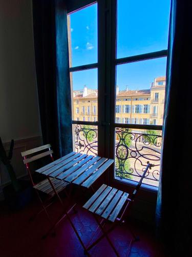 a window with a bench and a view of a building at Les Suites du Cours & Spa in Aix-en-Provence