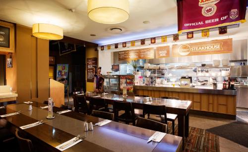 a restaurant with tables and chairs and a kitchen at Nightelier Mermaid Waters in Gold Coast