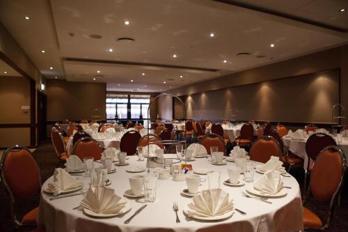 a banquet hall with white tables and chairs at Nightelier Mermaid Waters in Gold Coast