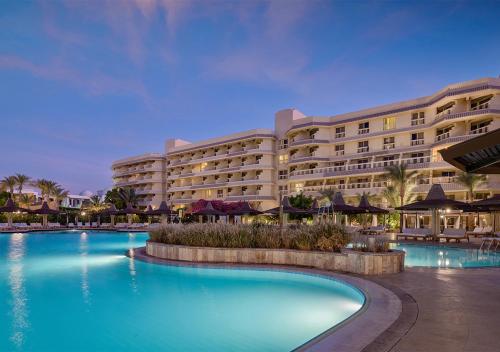 un hotel con piscina frente a un edificio en Sindbad Club en Hurghada