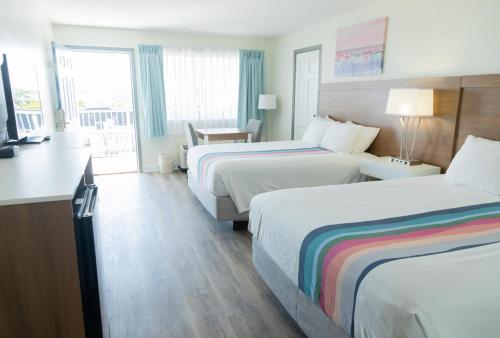 a hotel room with two beds and a balcony at Admiral on Baltimore in Rehoboth Beach