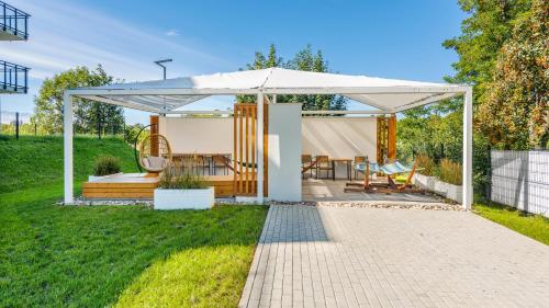 a white gazebo in the backyard of a house at Nexo, Sun & Snow in Puck