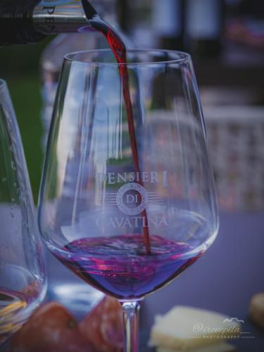 a wine glass withwine being poured into it at Pensieri di Cavatina in Castelnuovo Berardenga