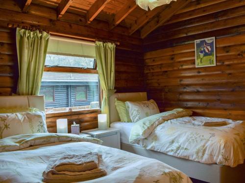1 dormitorio con 2 camas en una cabaña de madera en Forest View, en Strathyre