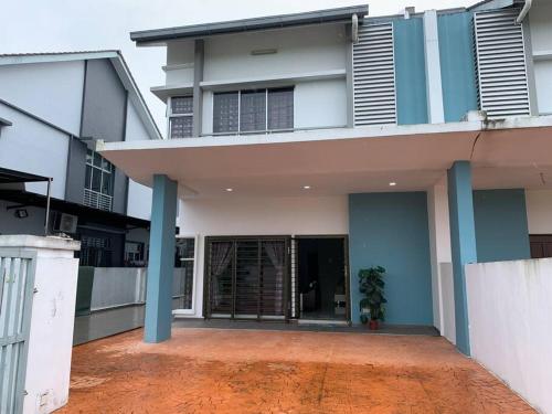 a large house with blue columns and a driveway at Hud hud Homestay Gelang Patah in Nusajaya