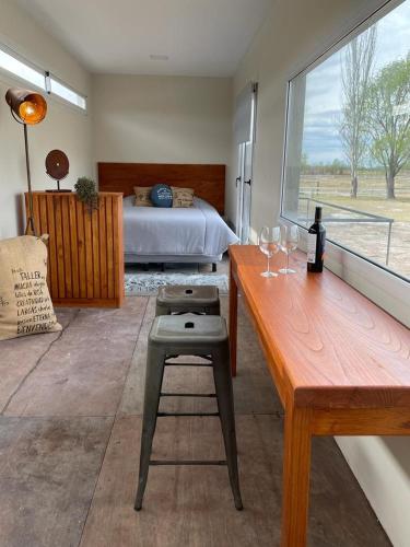 a bedroom with a bed and a table with wine glasses at Costa de Anzorena in Tunuyán