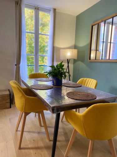 une salle à manger avec une table et des chaises jaunes dans l'établissement Appartement moderne en plein centre D'Epernay, à Épernay