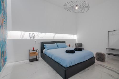 ein Schlafzimmer mit einem Bett mit blauen Kissen in der Unterkunft Frida apartments by Dimore in Sicily in Syrakus