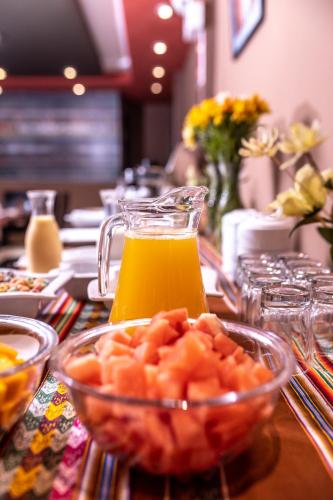 una jarra de cristal con zumo de naranja y un bol con comida en Hotel Ferré Boulevard, en Machu Picchu