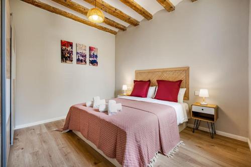 a bedroom with a large bed with red pillows at Apartamentos Circo Romano in Tarragona