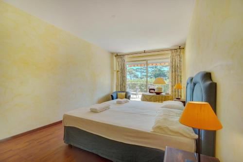 une chambre avec un grand lit et une fenêtre dans l'établissement comfortable 3 bedroom, superb south terrace, à Cannes
