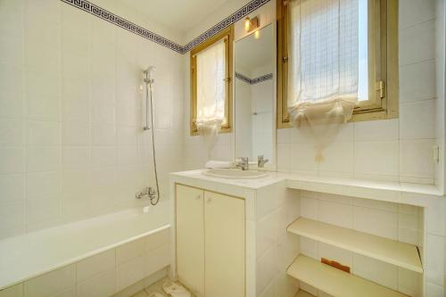 une salle de bain blanche avec un lavabo et une baignoire dans l'établissement comfortable 3 bedroom, superb south terrace, à Cannes