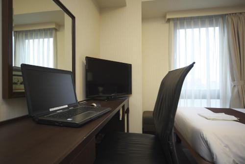 a laptop computer sitting on a desk in a hotel room at Shizutetsu Hotel Prezio Shizuoka-Ekikita in Shizuoka