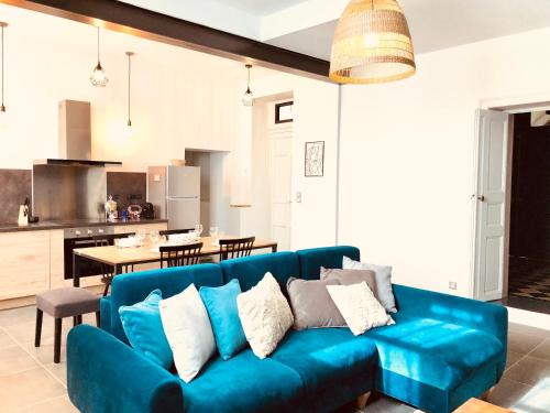 a living room with a blue couch and a kitchen at Le Pari Nîmois, avec Parking, Centre Ville Arènes in Nîmes