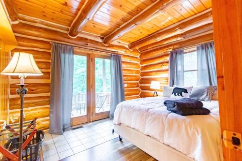 1 dormitorio con 1 cama en una cabaña de madera en Hygge Up North Cabin en Traverse City
