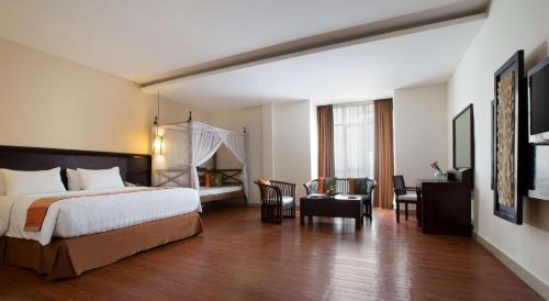Cette chambre comprend un lit et un bureau. dans l'établissement Best Western Resort Kuta, à Kuta