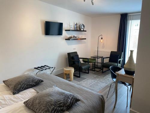 a bedroom with a bed and a desk and chairs at Am Meerturm in Xanten