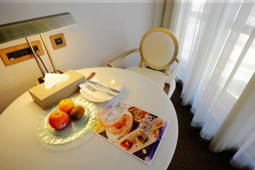a white table with a plate of fruit on it at City Suites - Taipei Nandong in Taipei