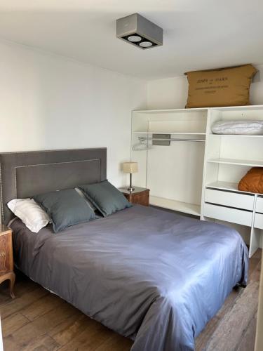 a bedroom with a large bed and white shelves at 11 de abril. Loft in Bahía Blanca