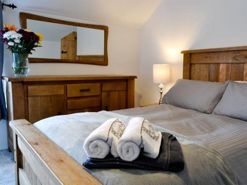 a bedroom with a bed with towels and a mirror at Bryn Hyfryd in Llanrwst