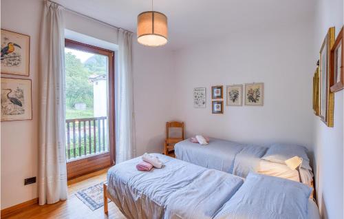 1 dormitorio con 2 camas y ventana con balcón en Amazing Apartment In Comano Terme With House A Mountain View, en Comano Terme