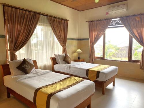 a hotel room with two beds and a window at Villa Agung Khalia Ubud in Ubud
