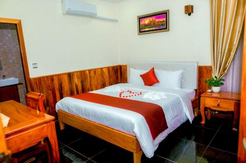una camera da letto con un grande letto con cuscini rossi di Mohasal Angkor Boutique a Siem Reap
