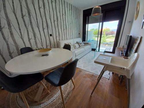 a living room with a white table and chairs at Precioso apartamento con terraza y piscina en Portonovo-Sanxenxo in Portonovo