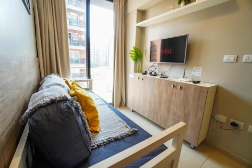 a room with a bed and a tv and a window at Rent for Days IV- Norte Vip in San Miguel de Tucumán