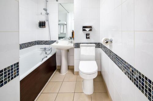 La salle de bains est pourvue de toilettes et d'un lavabo. dans l'établissement Mercure Glasgow City Hotel, à Glasgow