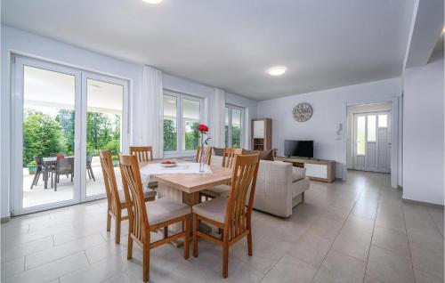 a dining room and living room with a table and chairs at Lovely Home In Zminj With Kitchen in Žminj