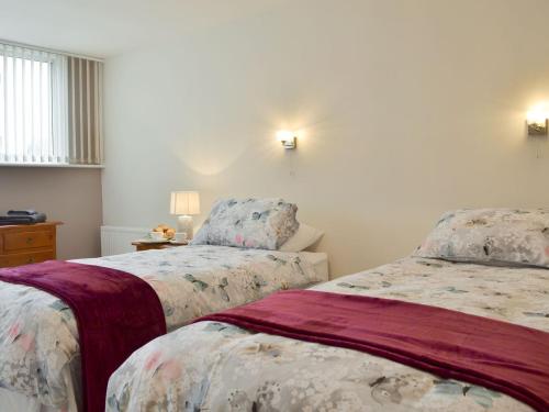 a bedroom with two beds and a table with lamps at The Warren in Seasalter