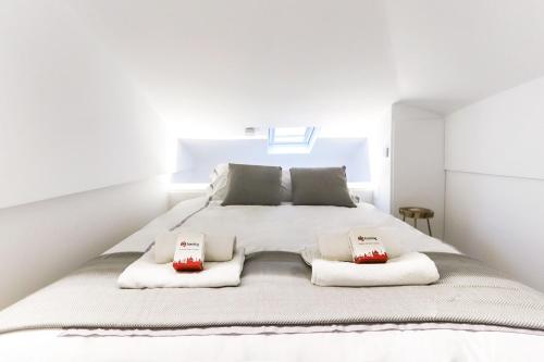a bedroom with a white bed with two pillows on it at CHARMING SANTOS by Homing in Lisbon