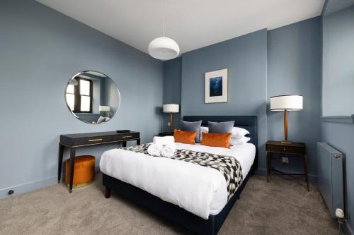 sypialnia z dużym łóżkiem z niebieskimi ścianami w obiekcie ALTIDO Stylish 2-bed flat in New Town w Edynburgu