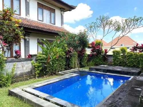 a swimming pool in the yard of a house at Villa Agung Khalia Ubud in Ubud
