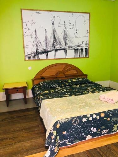 a bedroom with a bed and a painting on the wall at WAN'S ROOMSTAY LANGKAWI in Pantai Cenang