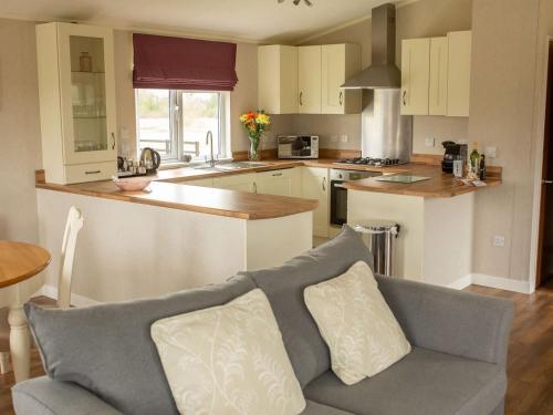 a living room with a couch and a kitchen at Beech - Ukc4530 in Darsham