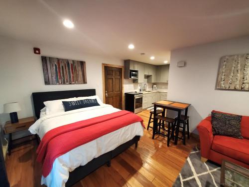 ein Schlafzimmer mit einem Bett und einem roten Stuhl sowie eine Küche in der Unterkunft Studio Purgatory Townhome 104 in Durango Mountain Resort