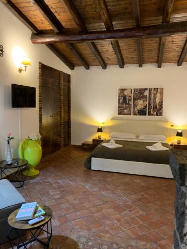 a room with two beds and a couch and a tv at B&B Villa Loriana in Milo