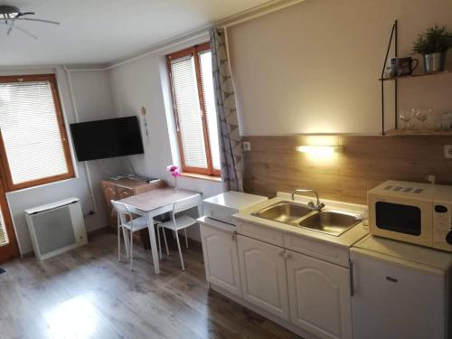 een keuken met een spoelbak en een magnetron bij Liberty Apartman Bükfürdő in Bük